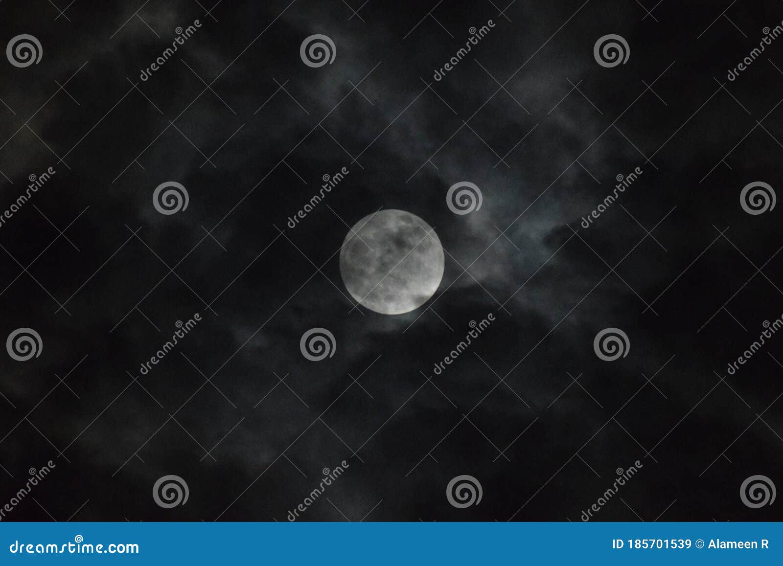 tamil nadu, india - june-06-2020: penumbral lunar eclipse behind clouds